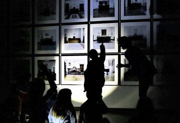 Kinder im Museum im Dunklen, Bilder an der Wand werden mit Taschenlampe angestrahlt